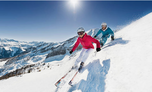 deux skieurs qui descendent une piste en skis