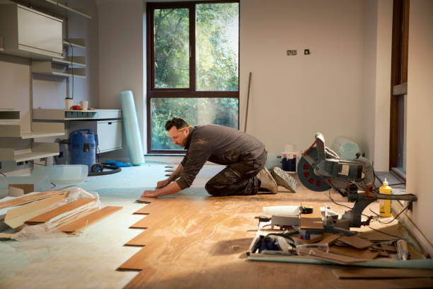 Homme qui pose du parquet dans un salon