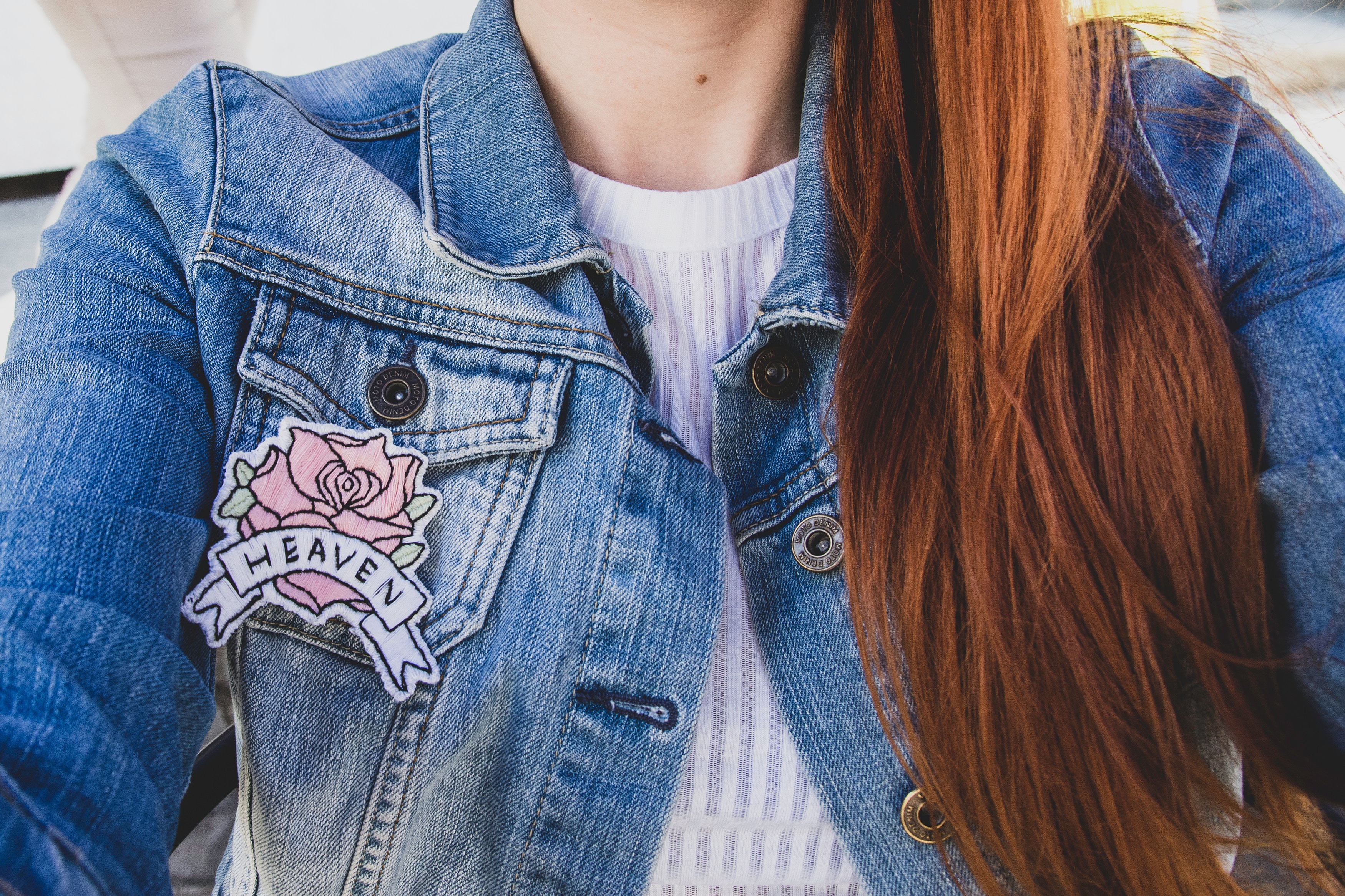 Jeune femme portant une veste en jean avec un écusson en forme de fleur