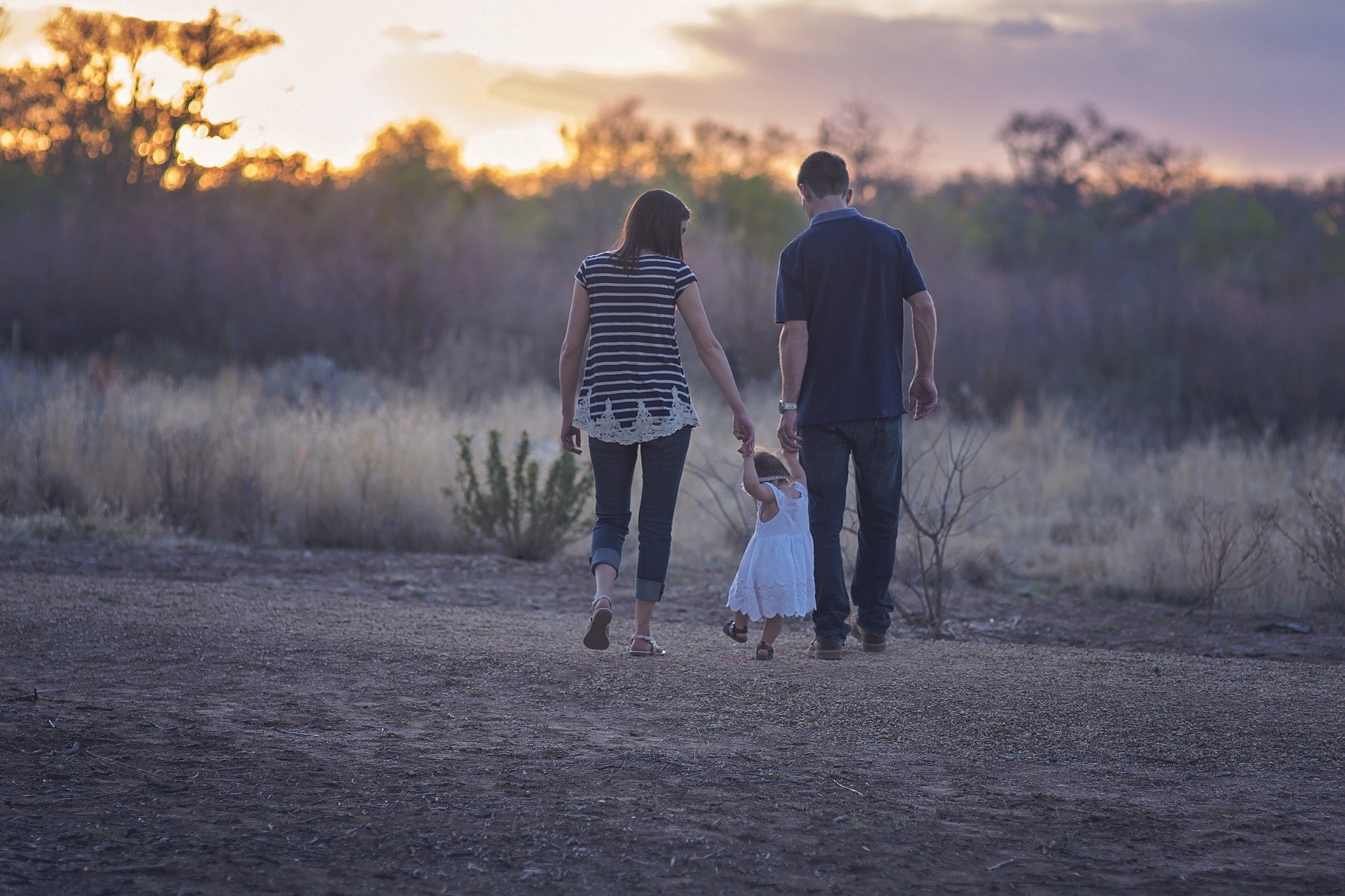 Photo de dos d'une famille avec un enfant dans un champ