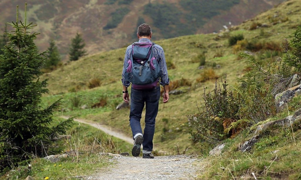 homme qui porte un sac à dos de randonnée